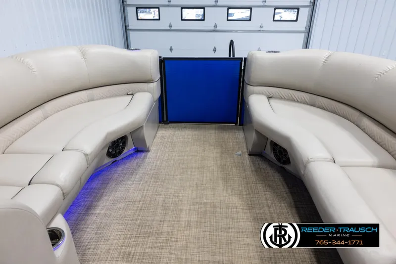 Slide: The Image of 2018 Cypress Cay 233 Seabreeze boat interior with beige seating and blue accent lighting. - 17