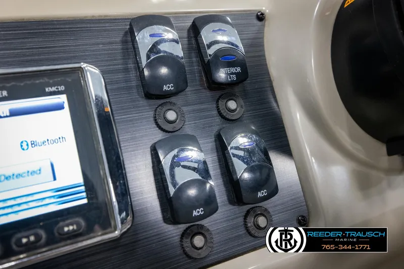 Slide: The Image of Control panel of 2018 Cypress Cay 233 Seabreeze boat with Bluetooth display and switches. - 23
