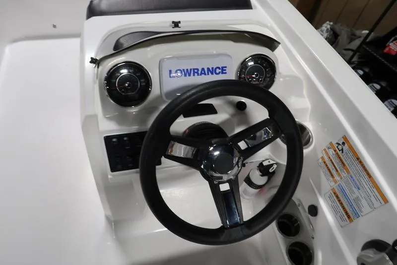 Slide: The Image of 2023 Hurricane SunDeck Sport 205 OB dashboard with steering wheel and Lowrance display. - 12
