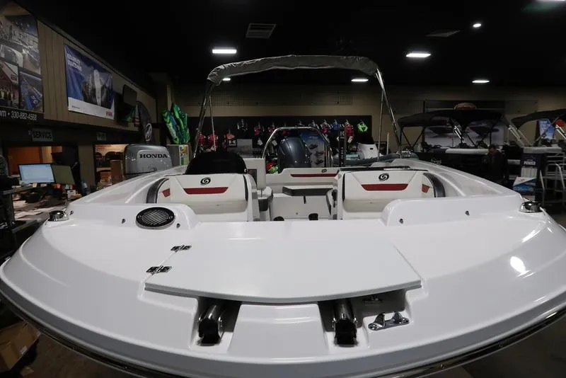 Slide: The Image of 2023 Hurricane SunDeck Sport 205 OB boat displayed in showroom, featuring sleek white design. - 6
