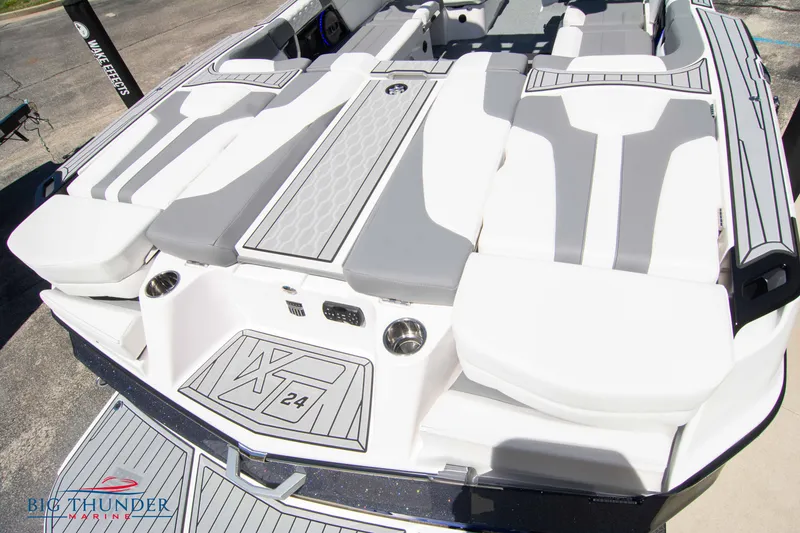 Slide: The Image of 2024 MasterCraft XT24 boat with sleek gray and white seating design. - 11
