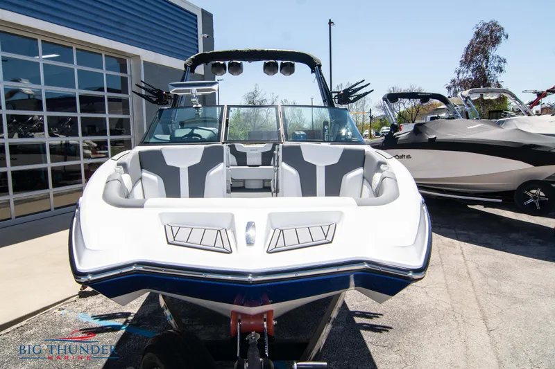 Slide: The Image of 2024 MasterCraft XT24 boat with sleek design and modern seating, displayed outdoors. - 2