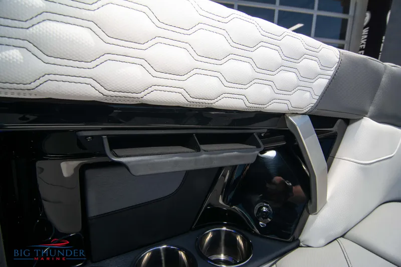 Slide: The Image of 2024 MasterCraft XT24 interior with hexagonal stitching and cup holders. - 32