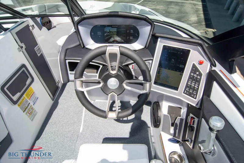 Slide: The Image of 2024 MasterCraft XT24 boat cockpit with modern steering wheel and digital controls. - 35