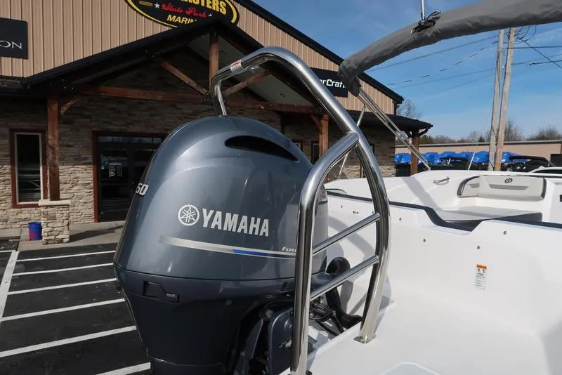 Slide: The Image of 2023 Hurricane SunDeck Sport 205 OB with Yamaha outboard motor in a dealership lot. - 2