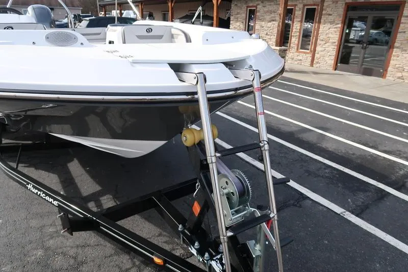 Slide: The Image of 2023 Hurricane SunDeck Sport 205 OB boat on trailer with ladder, parked outdoors. - 20