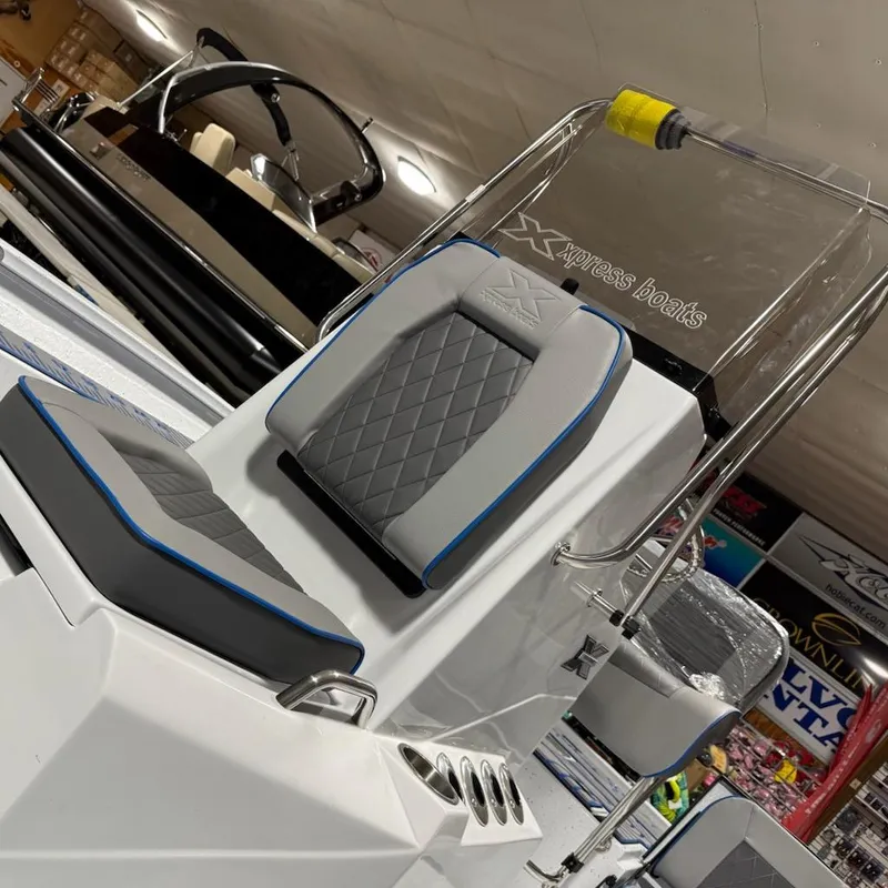 Slide: The Image of 2025 Express H20 Bay boat seat with gray and blue accents in showroom. - 13