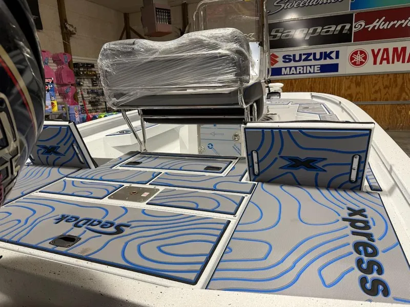 Slide: The Image of 2025 Express H20 Bay boat interior with custom blue and gray deck design in showroom. - 7