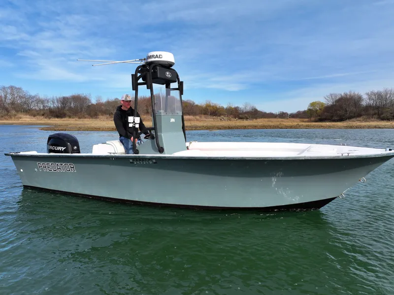 Slide: The Image of 2003 Key Largo 216cc boat on water with person steering, clear sky background. - 0