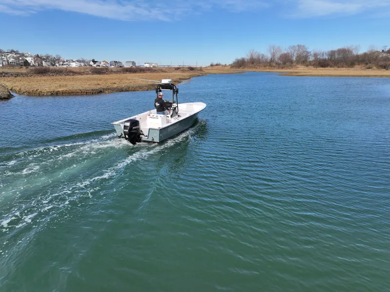 Slide: The Image of 2003 Key Largo 216cc boat cruising on a calm river under a clear blue sky. - 6