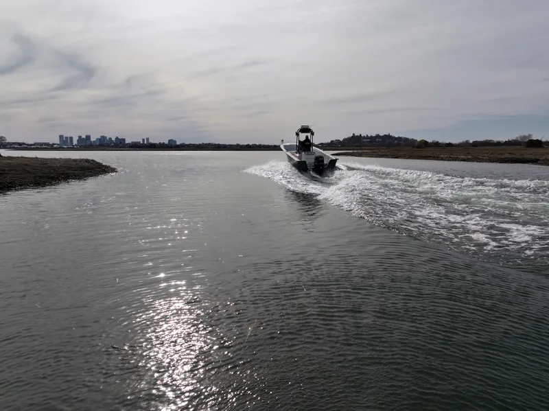Slide: The Image of Boat cruising on a calm waterway, Key Largo 216cc, 2003 model, city skyline in background. - 7