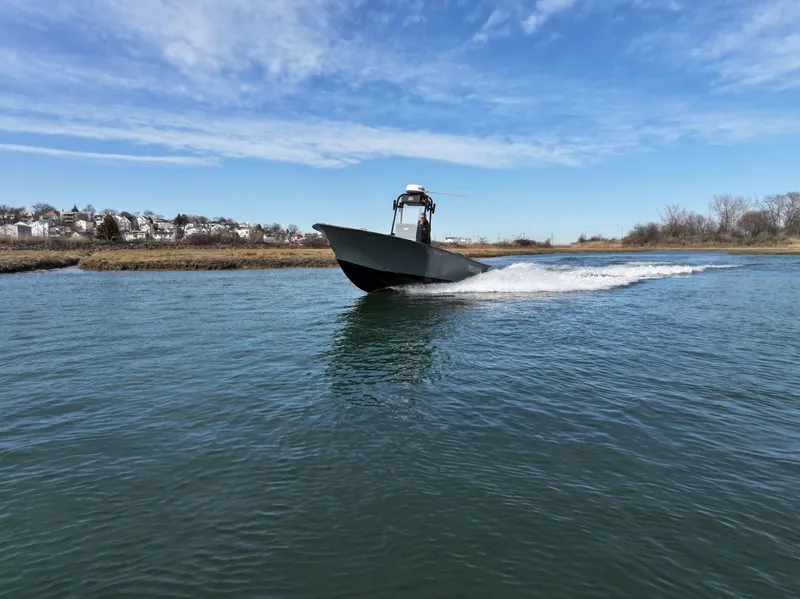 Slide: The Image of 2003 Key Largo 216cc boat cruising on a calm waterway under a clear blue sky. - 8