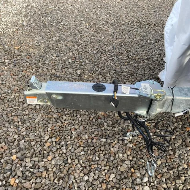 Slide: The Image of Trailer hitch of 2025 Xpress H20 Bass boat on gravel surface. - 7