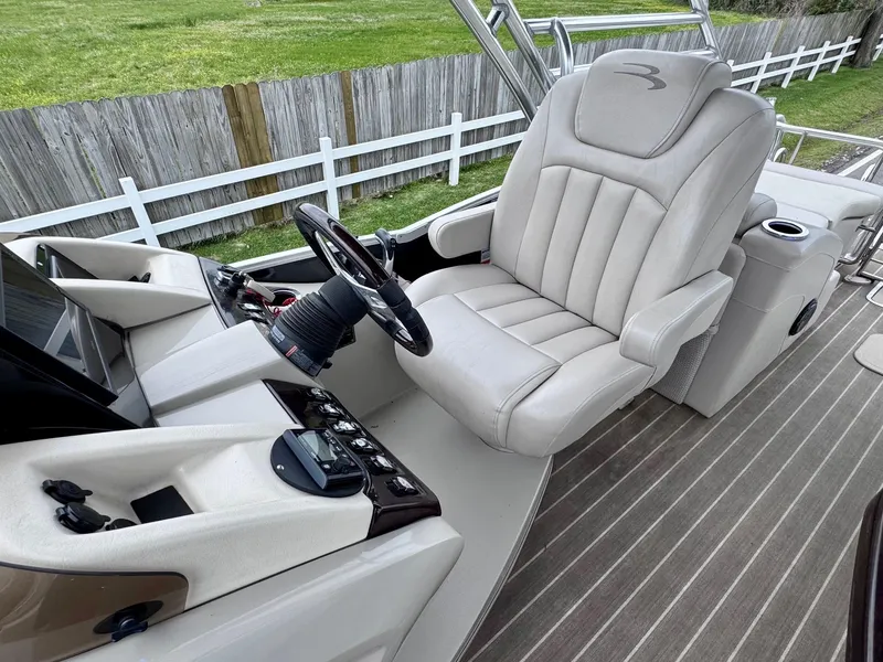 Slide: The Image of Captain's seat and helm of a 2014 Bennington 2575 RCW boat, featuring modern controls. - 11