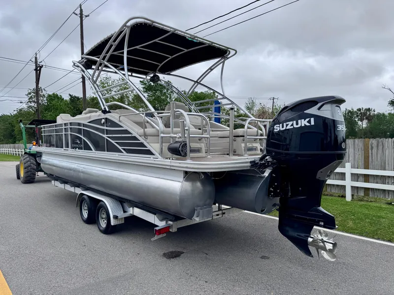 Slide: The Image of 2014 Bennington 2575 RCW pontoon boat with Suzuki outboard motor on trailer. - 3