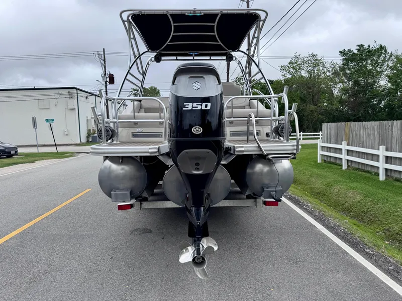 Slide: The Image of 2014 Bennington 2575 RCW pontoon boat with Suzuki 350 outboard motor on a road. - 4