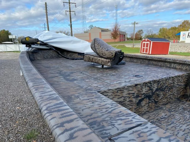 Slide: The Image of 2025 Xpress XP200 Catfish boat with camouflage design, parked outdoors on gravel. - 5