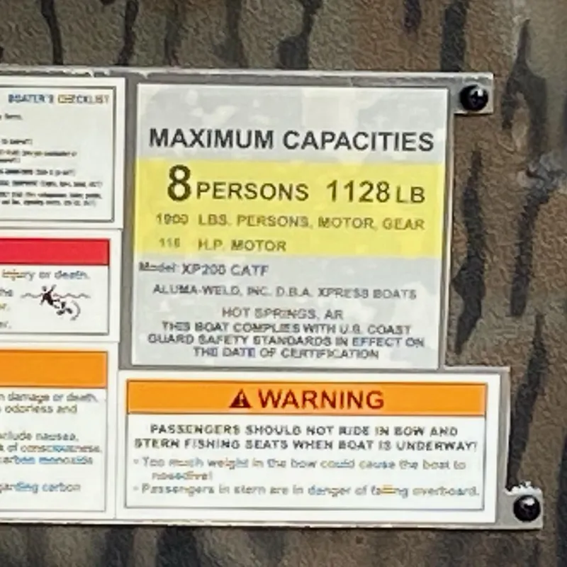 Slide: The Image of 2025 Xpress XP200 Catfish capacity plate: 8 persons, 1128 lbs, 115 HP motor warning. - 7