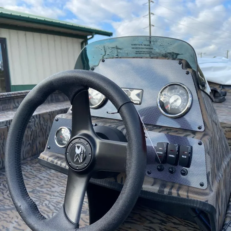 Slide: The Image of 2025 Xpress XP200 Catfish boat dashboard with steering wheel and gauges. - 9