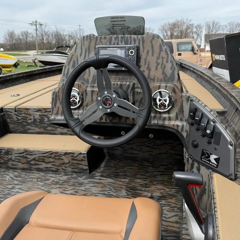 Slide: The Image of 2025 Xpress H18 Bass boat interior with steering wheel and control panel. - 5
