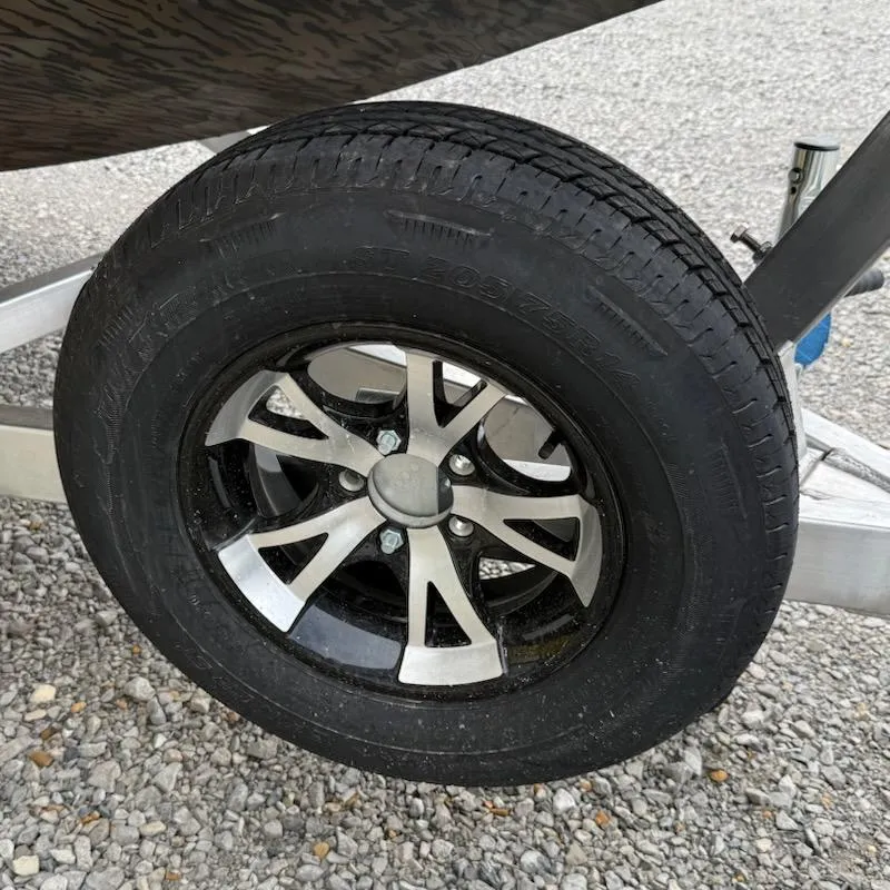 Slide: The Image of 2025 Xpress H18 Bass trailer wheel on gravel surface. - 9