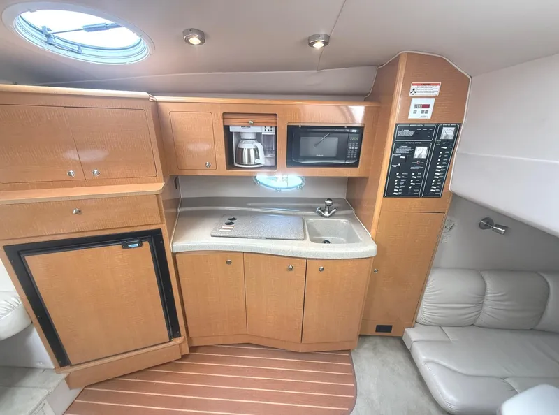 Slide: The Image of 2008 Larson 310 Cabrio boat interior with kitchenette, featuring microwave, coffee maker, and sink. - 13