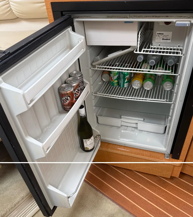 Slide: The Image of Open mini fridge on Larson 310 Cabrio boat, stocked with drinks and wine. - 14
