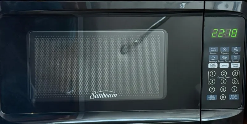 Slide: The Image of A Sunbeam microwave with digital display showing 22:18 and various control buttons. - 15