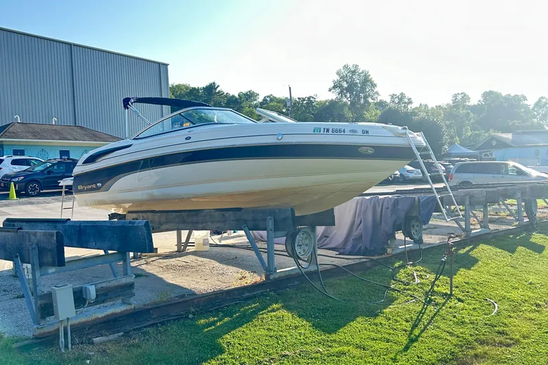 The Image of 2006 Bryant 219 boat on dry dock, sunny day, outdoor storage area. - 3