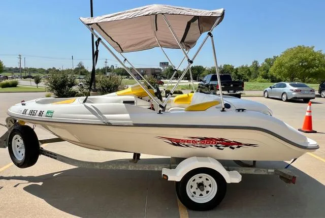 Slide: The Image of 2004 Sea-Doo Sportster LE DI boat on trailer with canopy, parked outdoors. - 10
