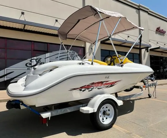 Slide: The Image of 2004 Sea-Doo Sportster LE DI boat on trailer with canopy, parked outside a building. - 13