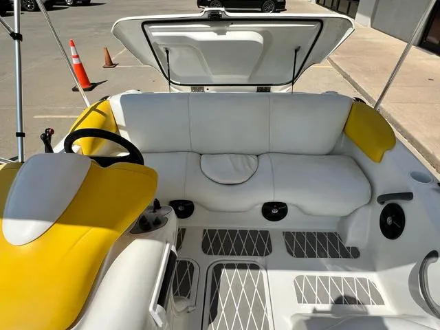 Slide: The Image of 2004 Sea-Doo Sportster LE DI interior with white and yellow seating, open storage compartment. - 6