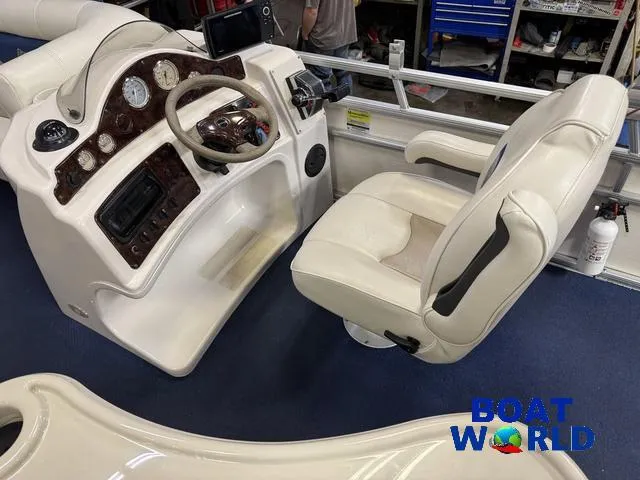 Slide: The Image of 2002 Godfrey 220 DF Pontoon boat cockpit with steering wheel and captain's chair. - 17