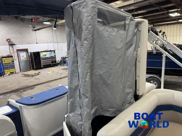 Slide: The Image of 2002 Godfrey 220 DF Pontoon with protective cover in a workshop setting. - 32