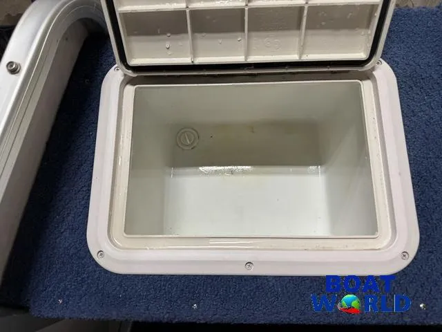 Slide: The Image of Open storage compartment on 2002 Godfrey 220 DF Pontoon boat, featuring blue carpeted surface. - 37