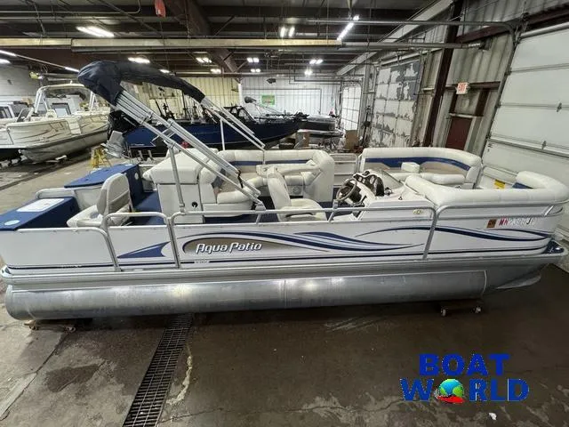 Slide: The Image of 2002 Godfrey 220 DF Pontoon boat in indoor storage, featuring white seating and blue accents. - 4