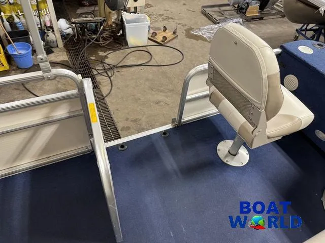 Slide: The Image of 2002 Godfrey 220 DF Pontoon interior with seating and railing in a workshop. - 45