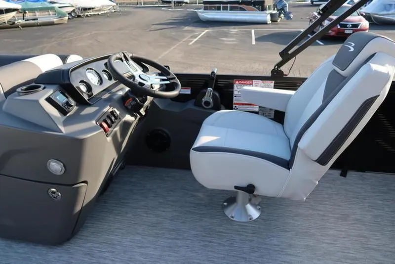 Slide: The Image of 2025 Bennington 22 SSB boat cockpit with steering wheel and captain's chair. - 14