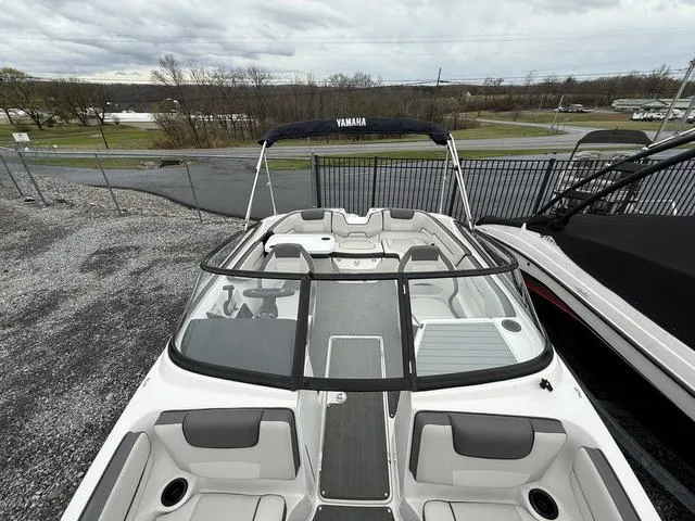 Slide: The Image of 2020 Yamaha SX190 boat with sleek design and spacious seating, parked outdoors. - 11