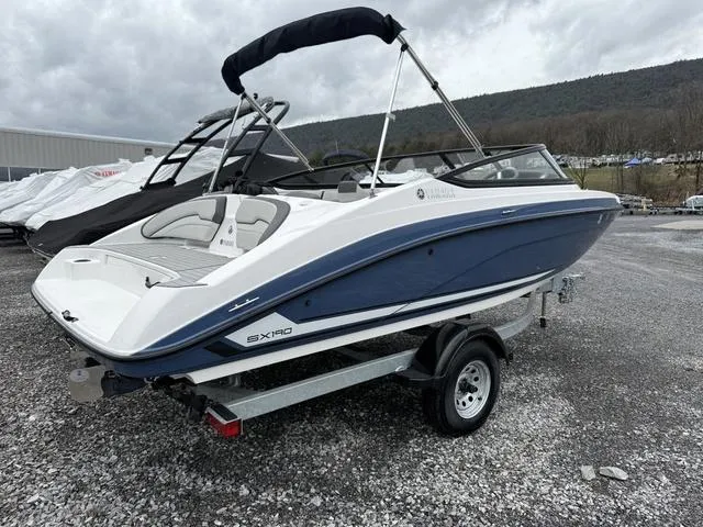 Slide: The Image of 2020 Yamaha Boats SX190 on trailer, blue and white, parked outdoors. - 4