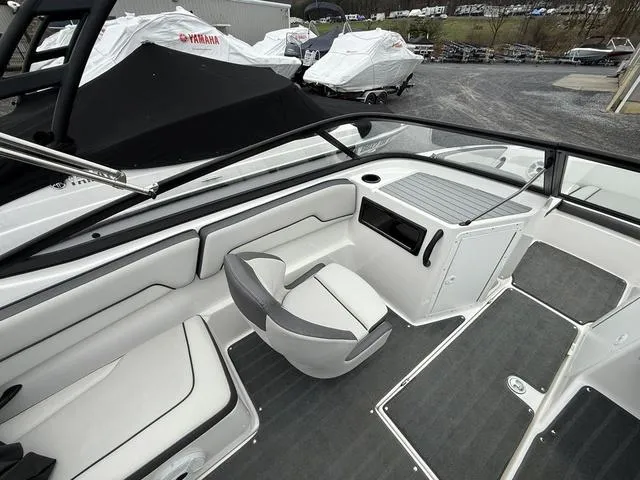 Slide: The Image of 2020 Yamaha Boats SX190 interior with seating and dashboard, parked outdoors. - 6