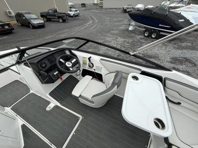 Slide: The Image of 2020 Yamaha Boats SX190 interior with steering wheel, seating, and table in a marina setting. - 7