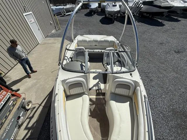 Slide: The Image of 2006 Stingray 195LR boat with white interior, parked outdoors near a building. - 11