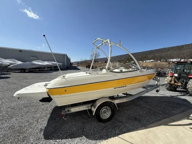 Slide: The Image of 2006 Stingray 195LR boat on trailer, parked outdoors under clear sky. - 4
