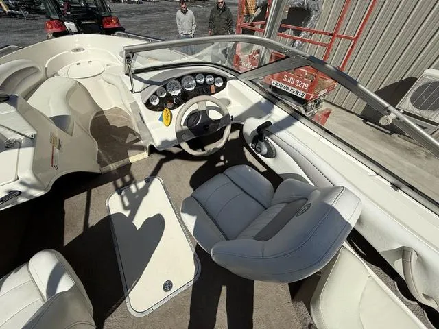 Slide: The Image of Interior of a 2006 Stingray 195LR boat with white seating and dashboard controls. - 9