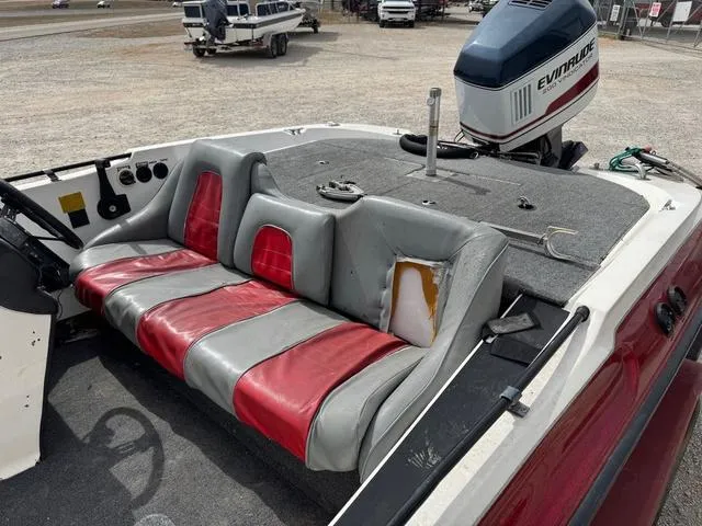 Slide: The Image of 1994 Stratos 201 PRO boat with red and gray seating, Evinrude motor, and visible wear. - 8