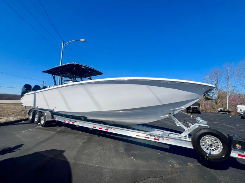 Slide: The Image of 2025 Nor-Tech 390 Sport Center Console boat on trailer under clear blue sky. - 0