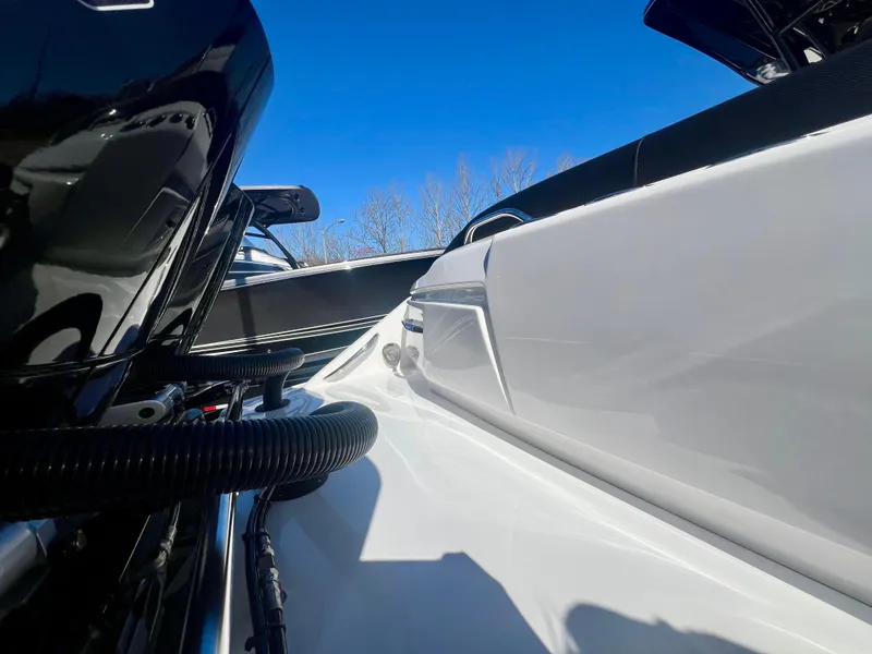 Slide: The Image of 2025 Nor-Tech 390 Sport Center Console boat, close-up view, sleek design, under clear blue sky. - 13