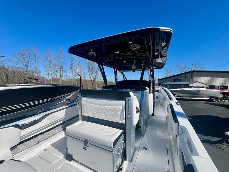 Slide: The Image of 2025 Nor-Tech 390 Sport Center Console boat with sleek seating and canopy, docked outdoors. - 15