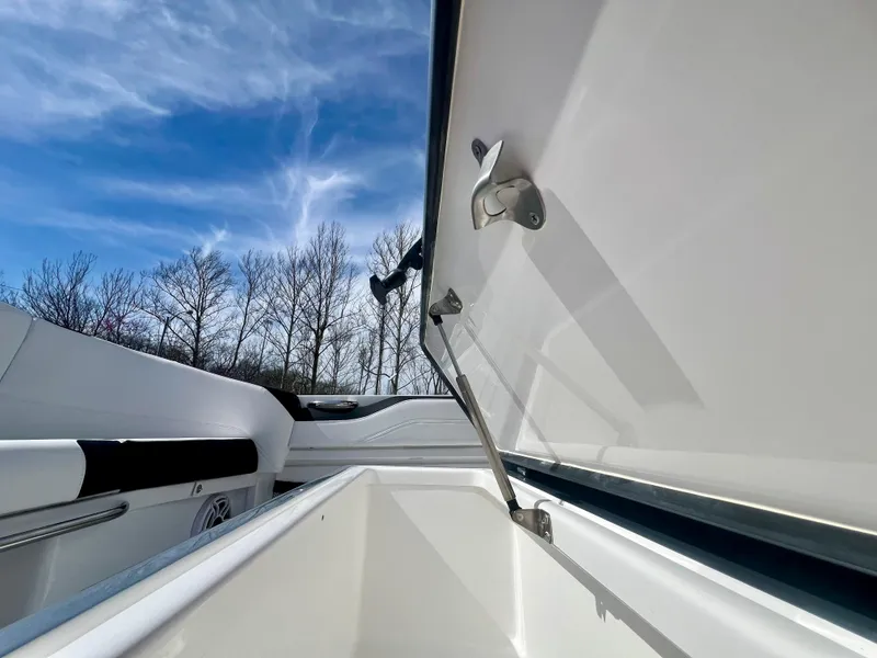 Slide: The Image of 2025 Nor-Tech 390 Sport Center Console with open storage compartment under clear blue sky. - 16